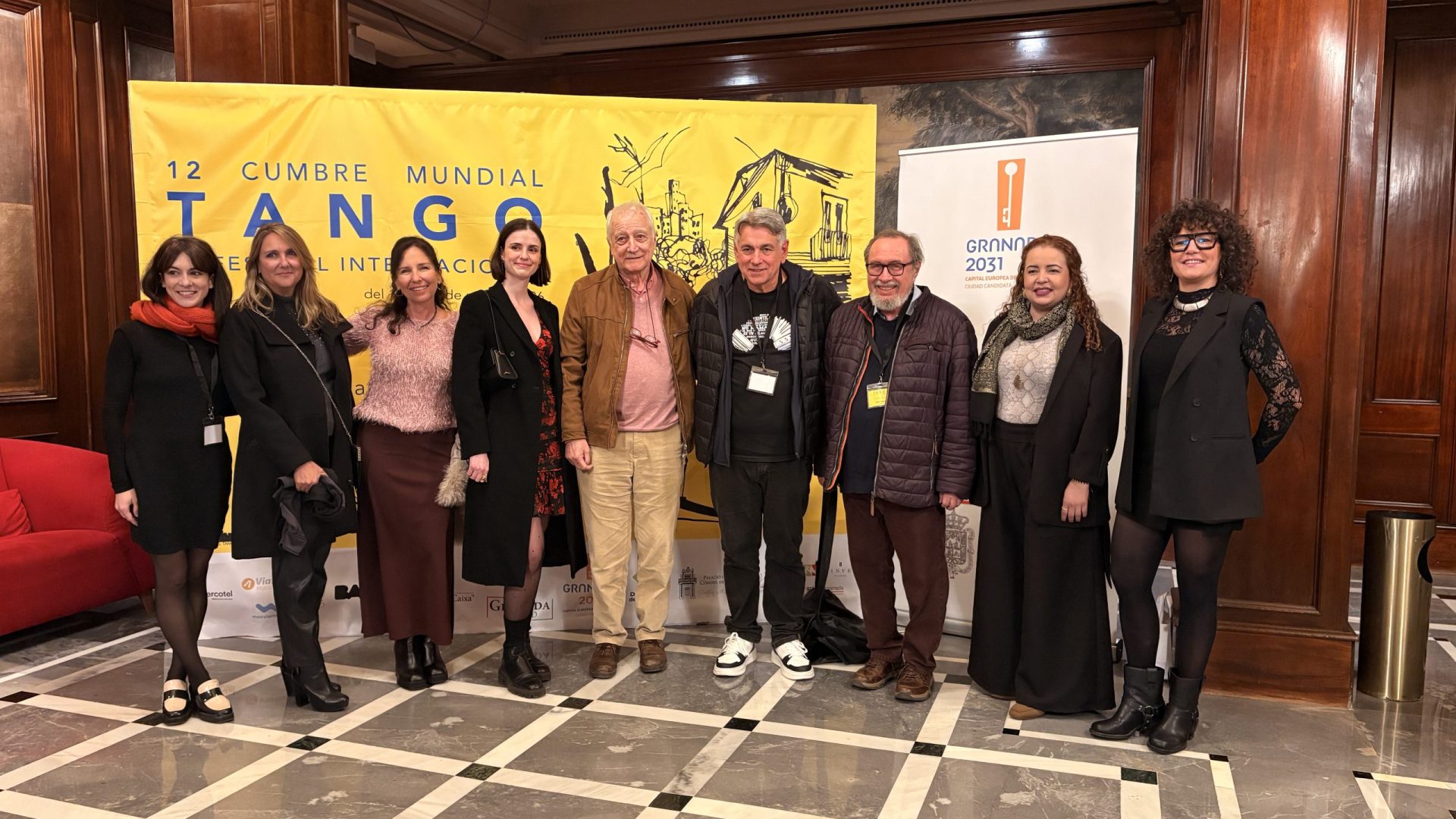 Large group of business delegates and corporate attendees posing together inside a premium historical venue during a traditional tango event organized by a DMC agency.
