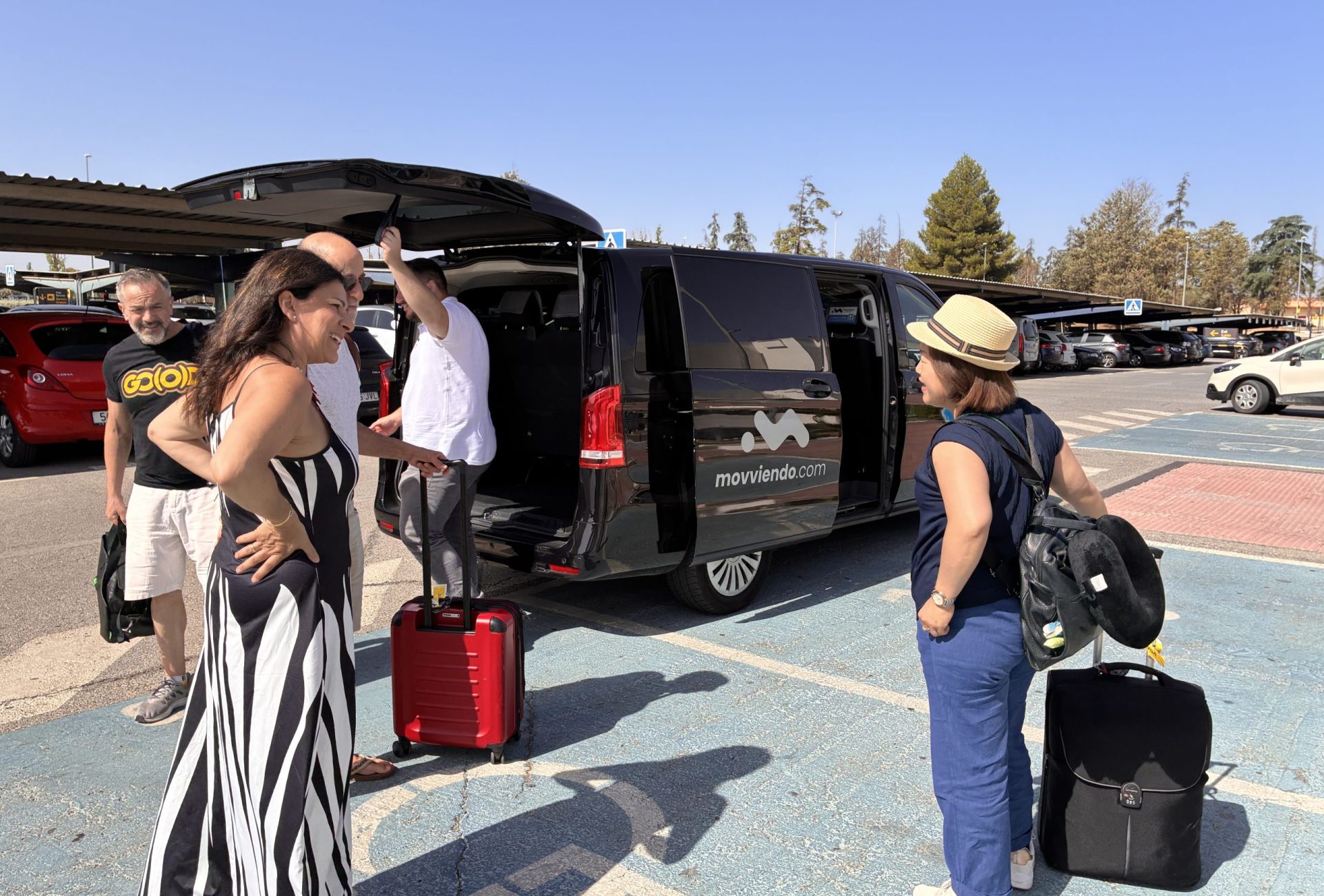 Corporate delegates arriving and boarding a premium black private transport van during a specialized airport transfer service managed by Movviendo.