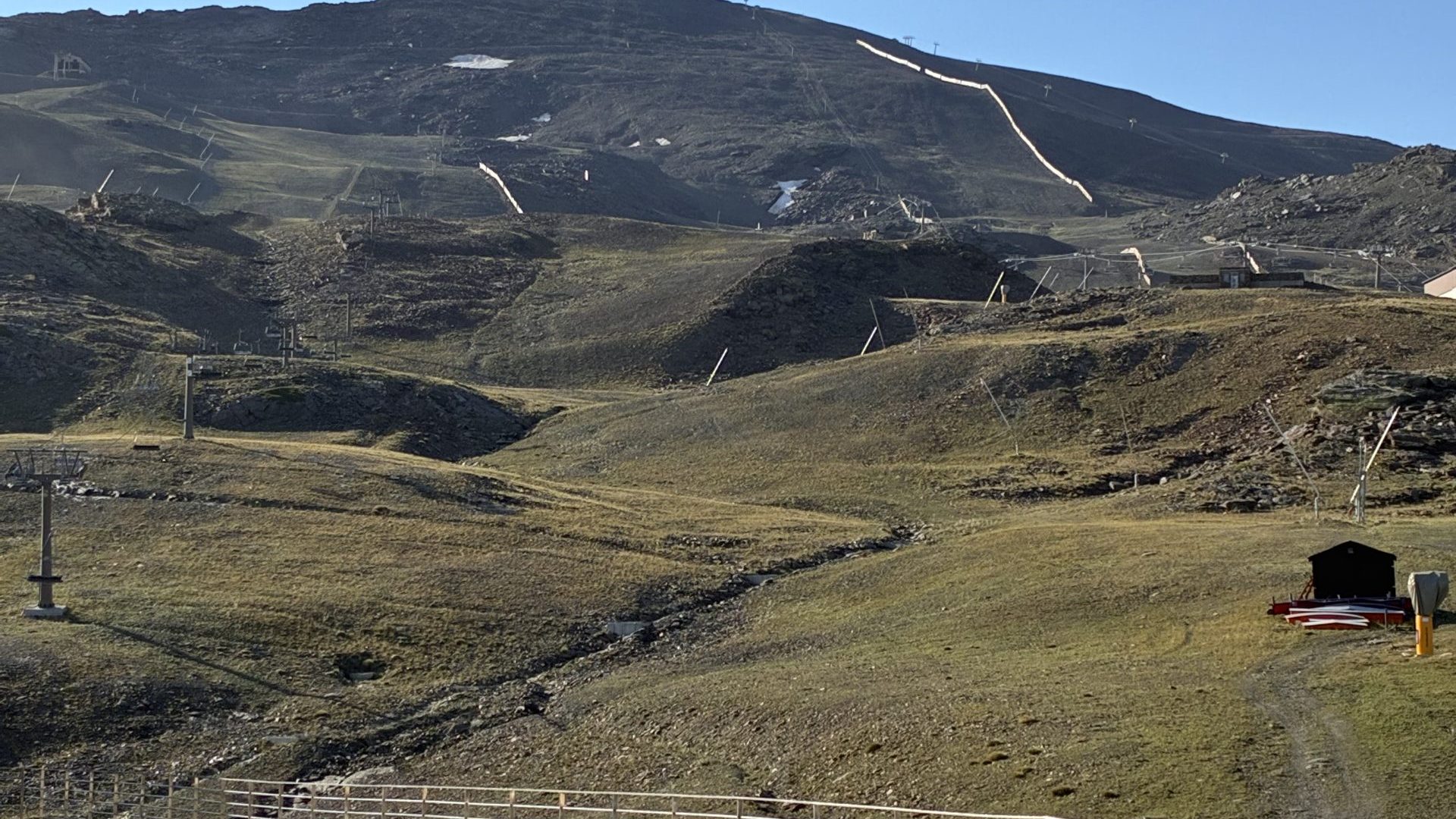 Panoramic summer landscape view of the majestic Sierra Nevada mountains and ski resort ski lifts under a clear blue sky during an outdoor team-building event.