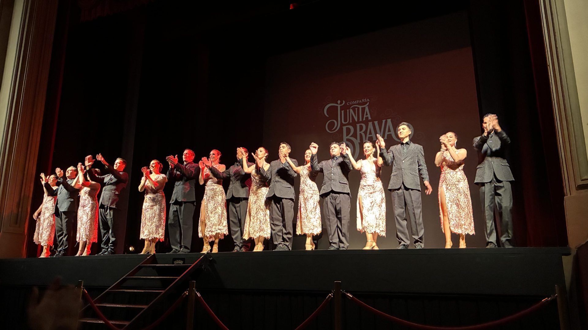 A large cast of artistic performers bowing on a theater stage at the end of a cultural show designed for an international corporate event and MICE travel incentive group.