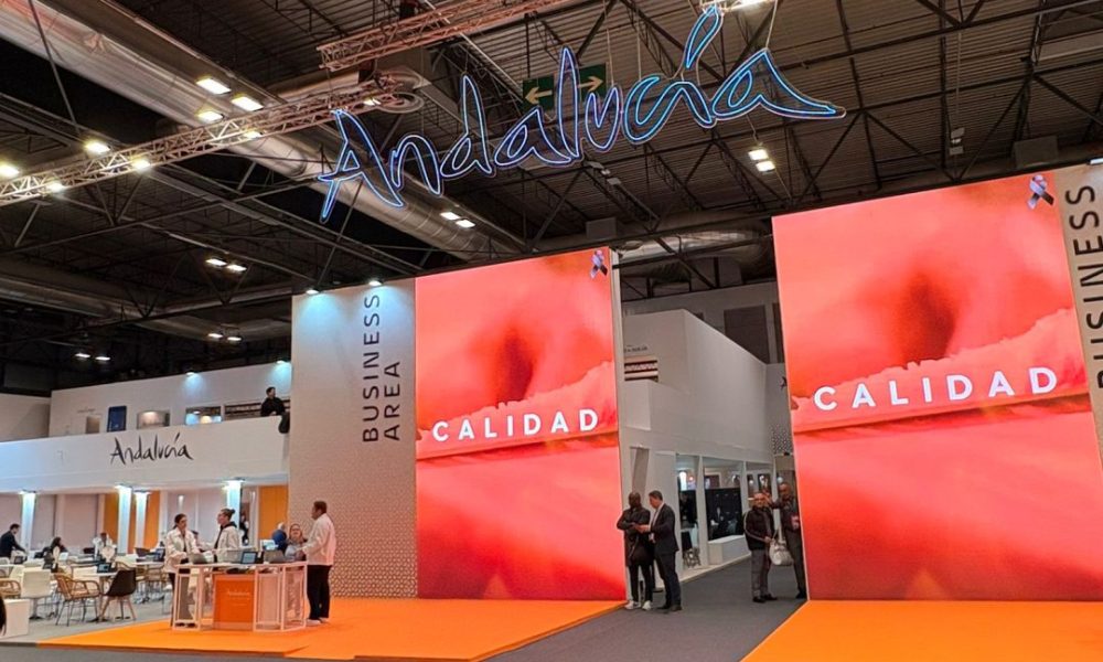Panoramic view of the vibrant Andalusia pavilion business area featuring large promotional screens and regional branding during a major corporate tourism convention.