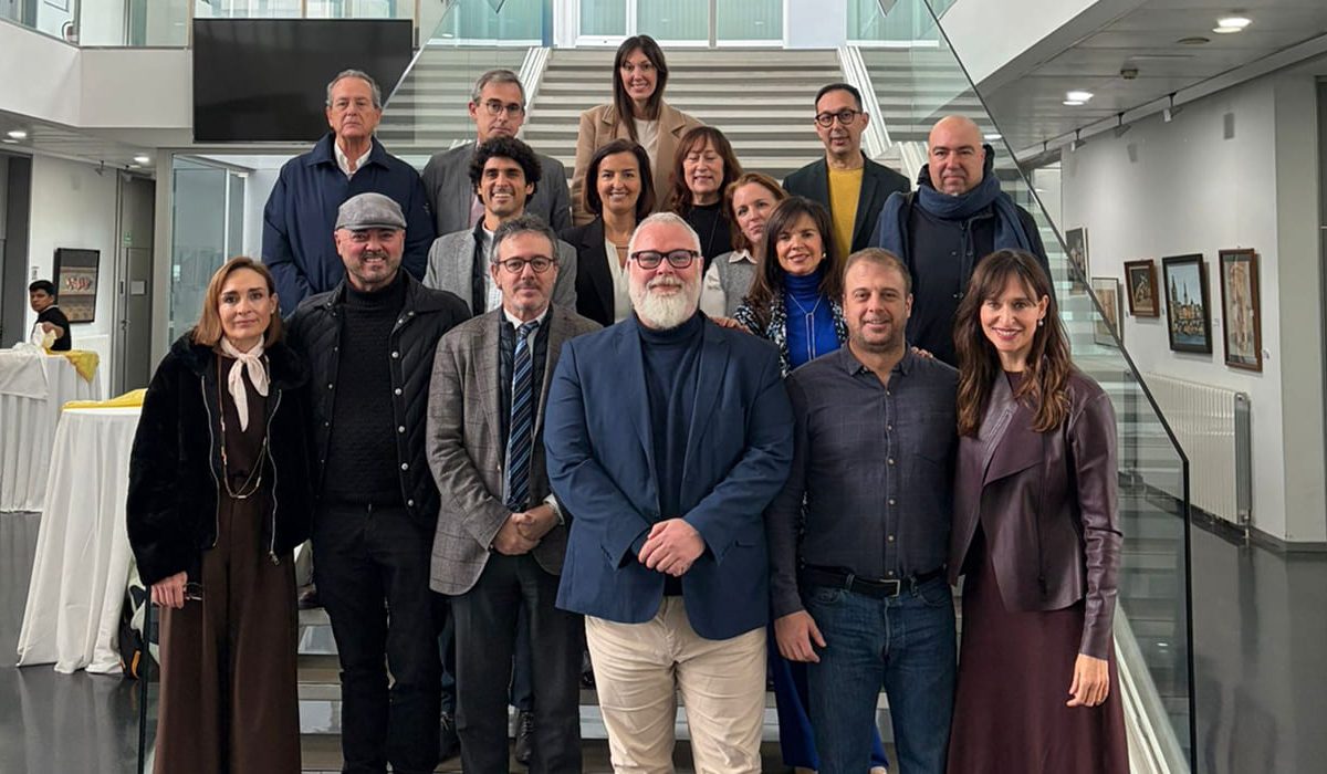 Group portrait of corporate delegates, managers, and event professionals posing together on an elegant indoor staircase before an institutional congress.