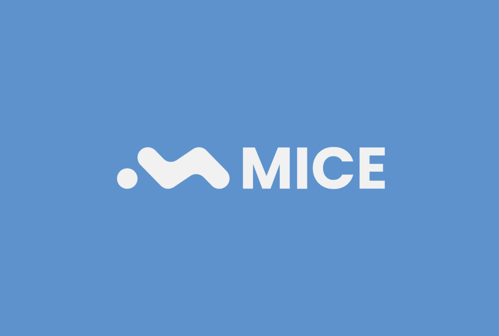 Ocho personas sentadas en un escenario formando un panel, con una gran pantalla detrás y la palabra MICE en letras grandes en primer plano.
