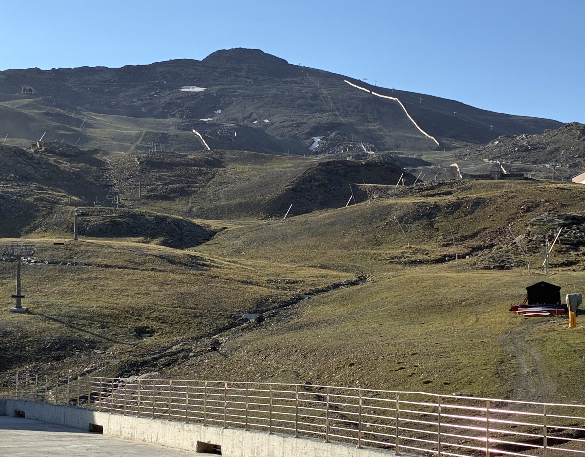 Paisaje natural de alta montaña en la estación de Sierra Nevada bajo un cielo azul despejado durante una inspección técnica de rutas de senderismo.